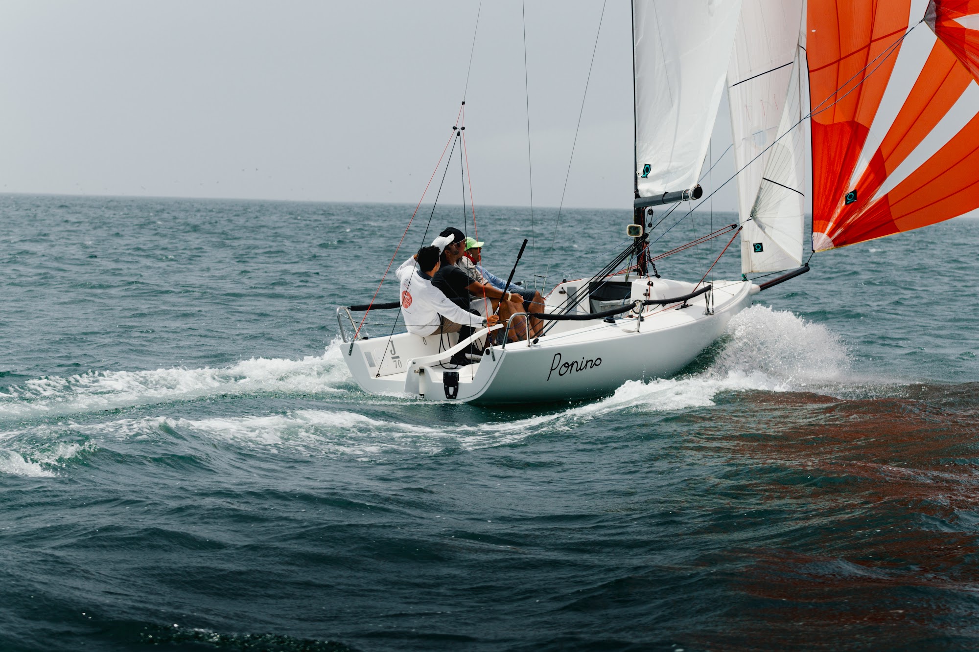J/70 Ponino navegando con spinnaker rojo en el mar peruano